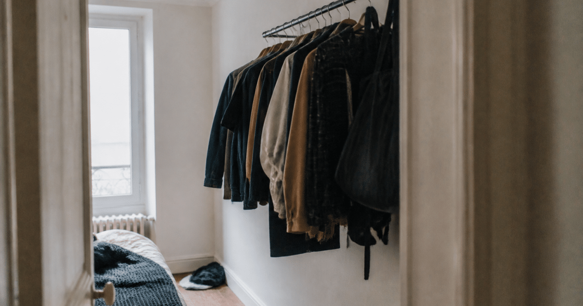 Penderie murale avec vetements suspendus dans chambre etroite