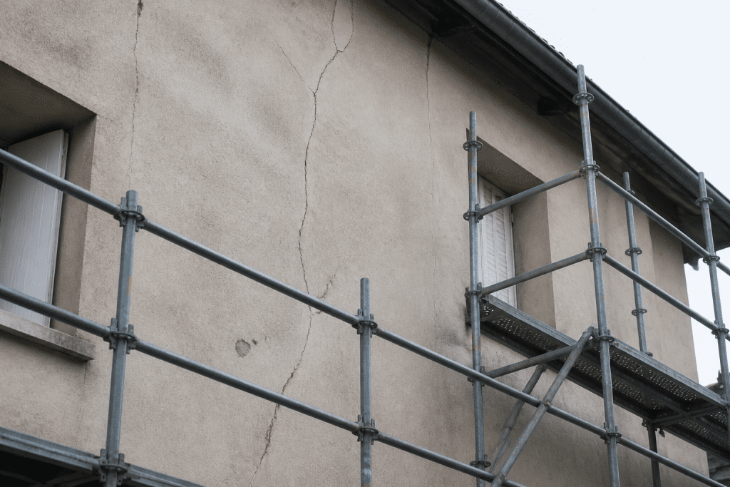 Facade avec fissures et echafaudage professionnel de reparation