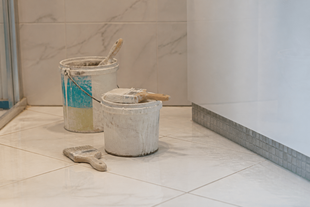 Carrelage salle bain blanc avec pots peinture et pinceaux