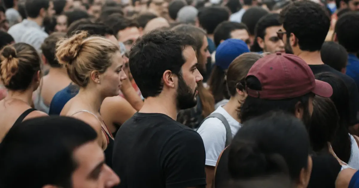 Foule dense de personnes debout cote a cote dans rue urbaine