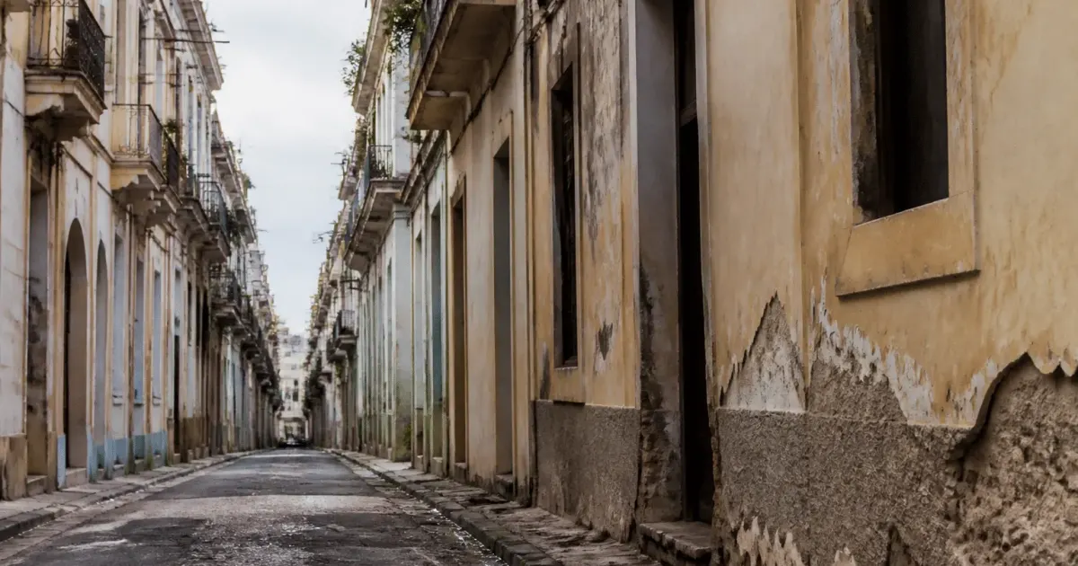 Rues urbaines délabrées avec immeubles vieillis et façades détériorées visiblement