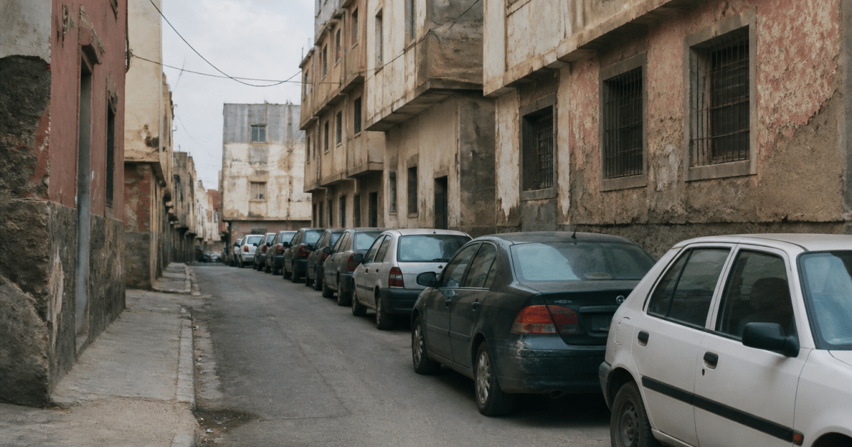 Rue urbaine avec immeubles delabres et voitures garees