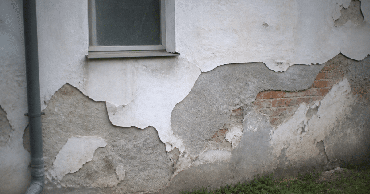 Facade exterieure avec enduit detache et mur expose par zones