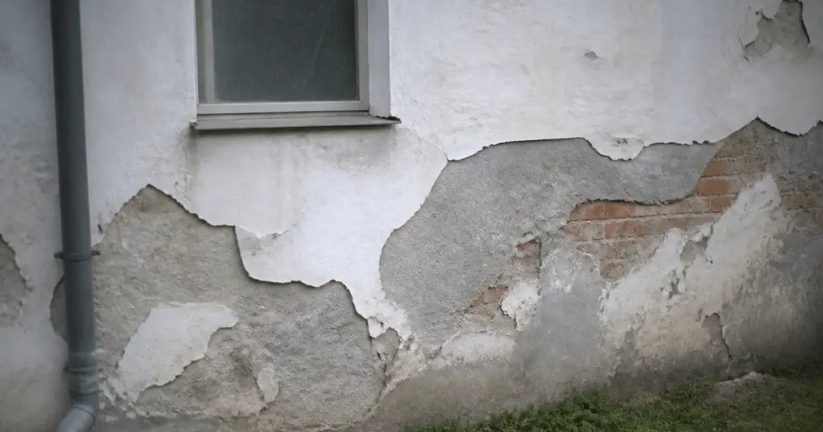 Facade exterieure avec enduit detache et mur expose par zones