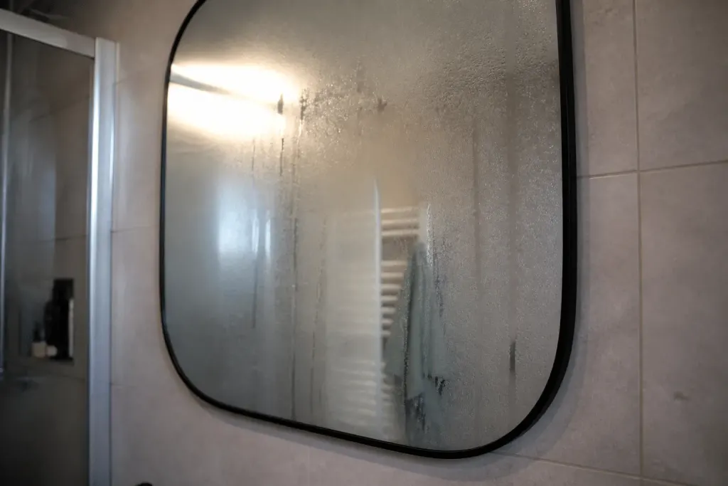 Salle bain avec miroir embuee et vapeur condensee