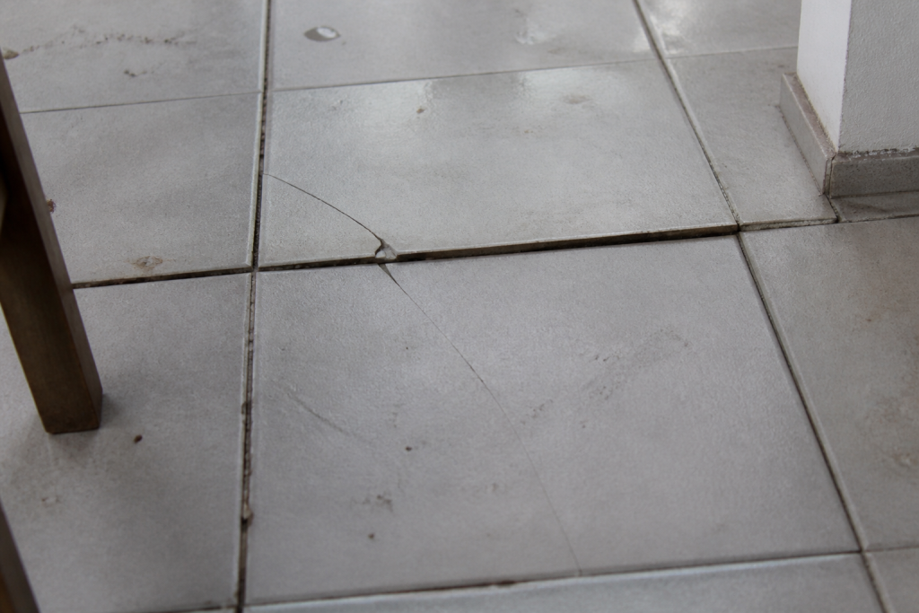 Carrelage fissure avec joints creux et inegalites visibles
