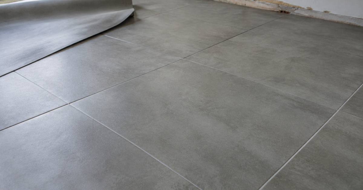 dalle pvc grise recouvrant carrelage avec joints apparents