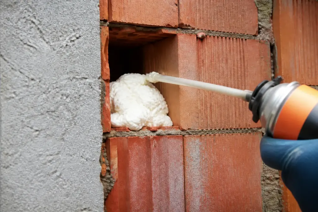 Mousse isolante blanche remplit cavite vide mur brique