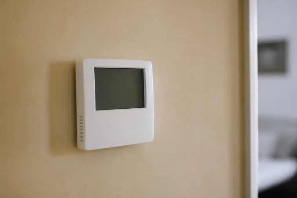 Petit boitier blanc avec ecran numerique sur mur beige