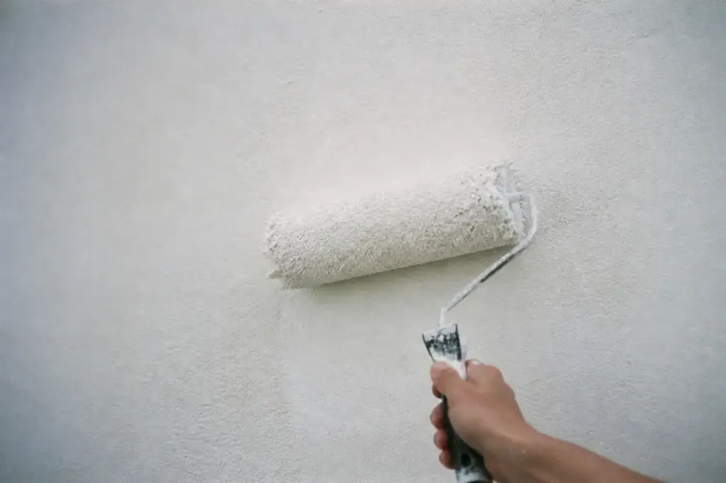 Rouleau a poils longs peignant un mur texture blanc