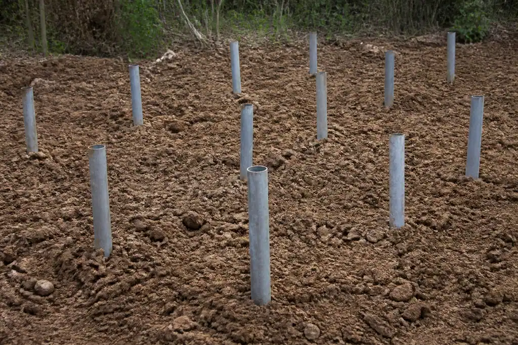 Tubes metalliques plantes dans un terrain argileux brun
